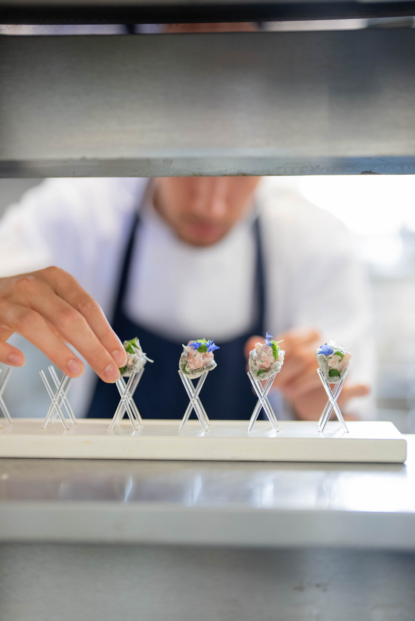 chef serving canape on levitation tray white blue