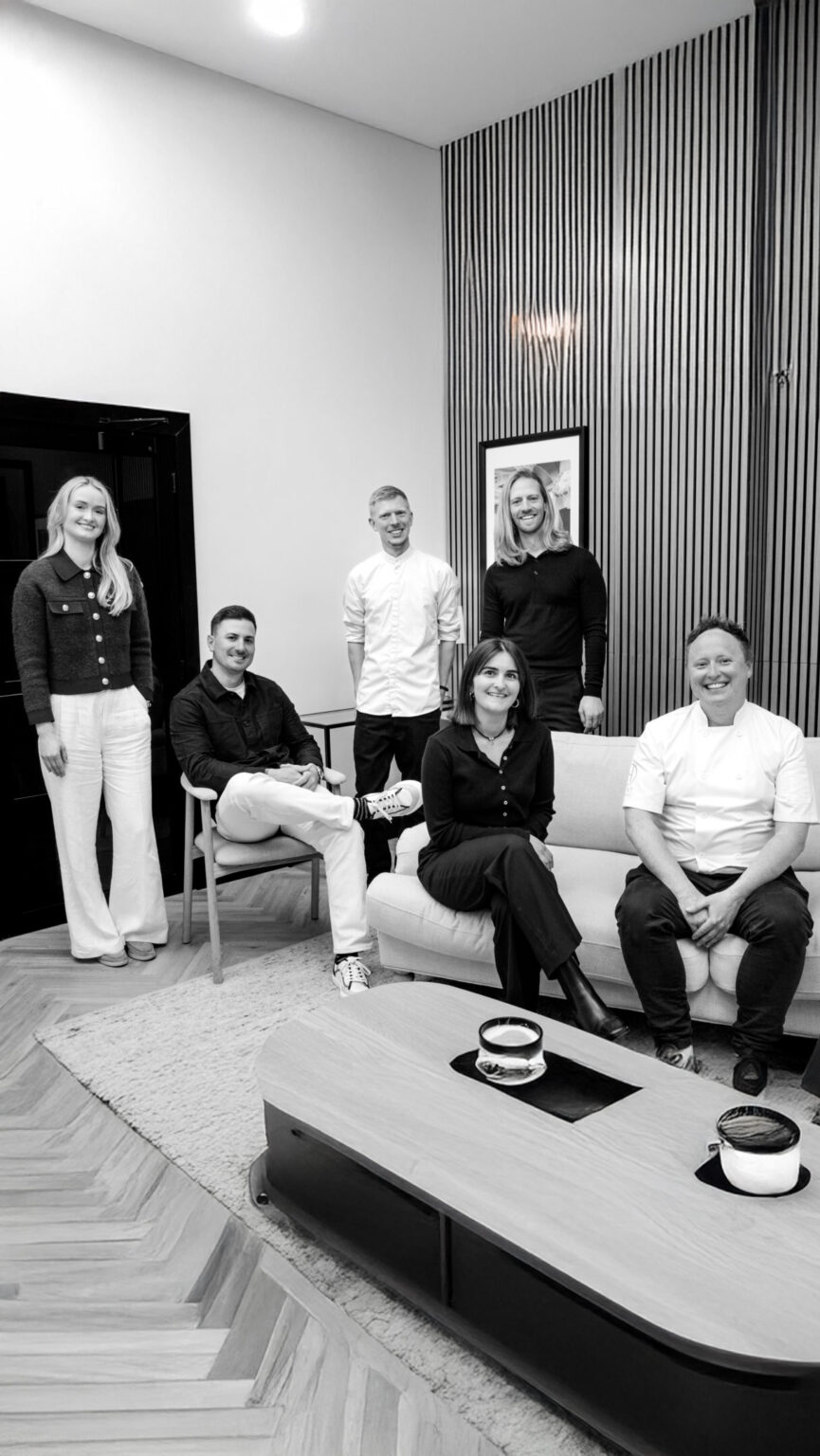 Staff standing and sitting around sofa couch black white
